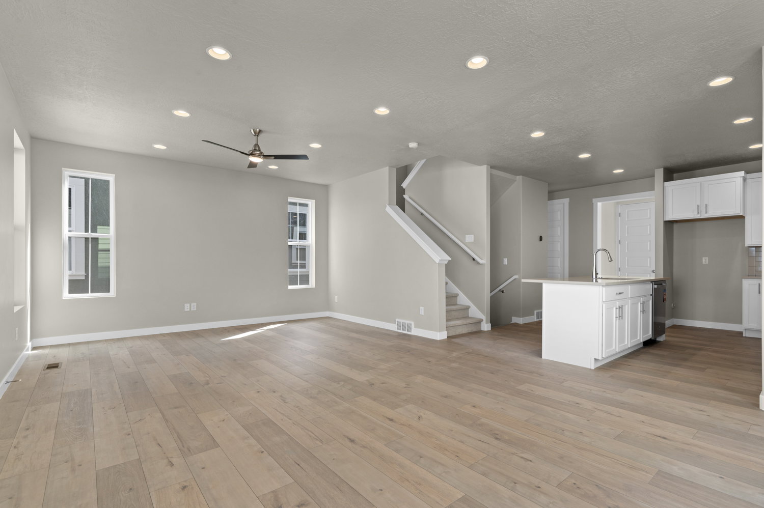 Unfurnished living room featuring recessed lighting, light wood-style flooring, ceiling fan, and healthy amount of natural light