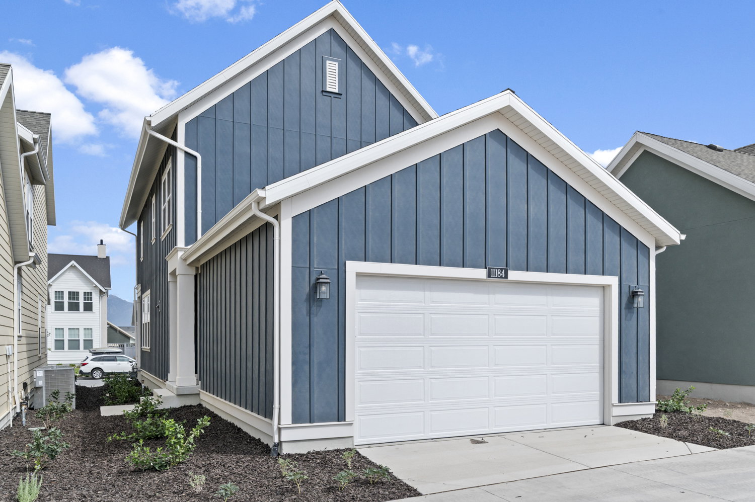 View of front of home with board and batten siding, an attached garage, and driveway