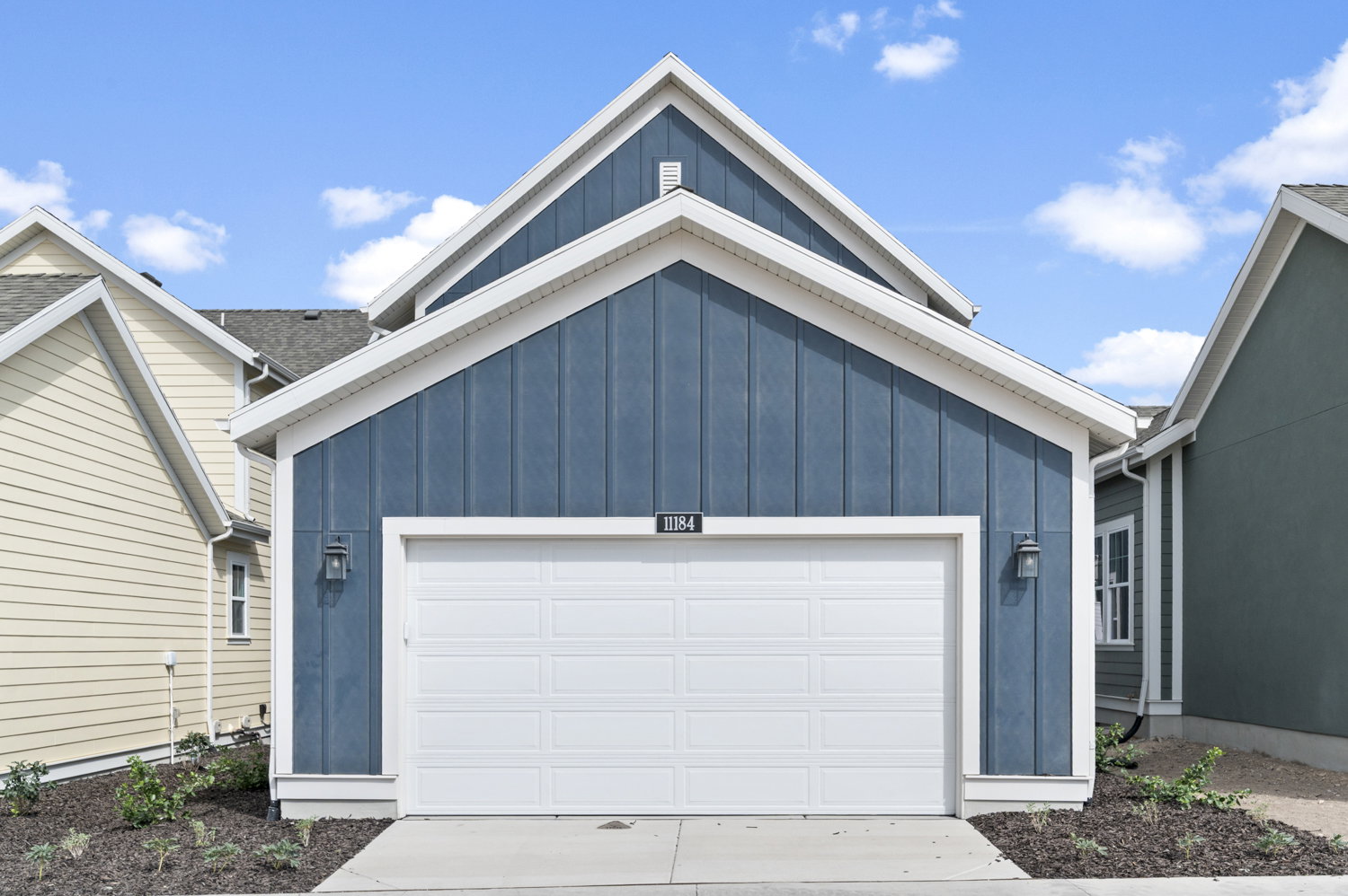 View of front facade featuring board and batten siding, concrete driveway, and a garage