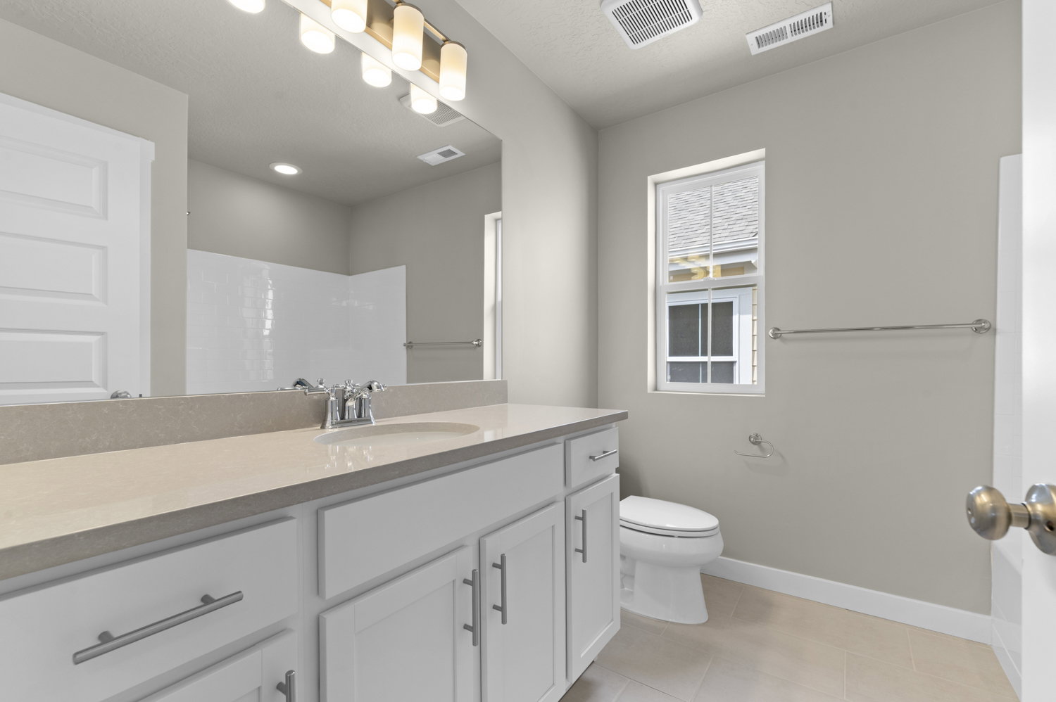 Bathroom featuring vanity, a shower, and light tile patterned floors