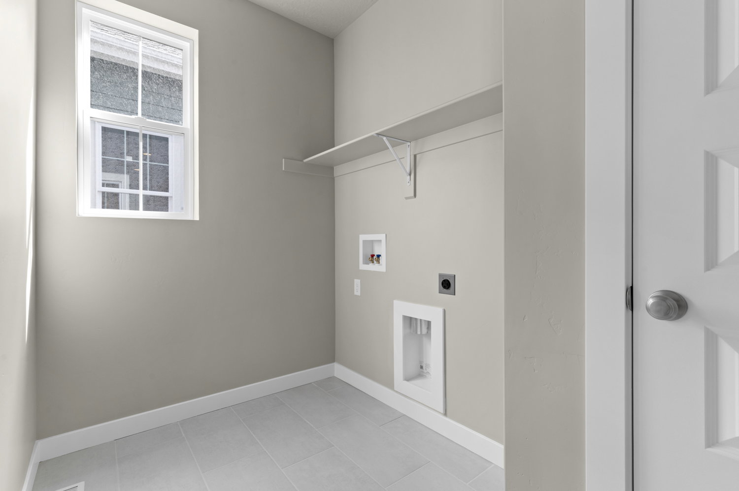 Laundry area featuring hookup for an electric dryer, hookup for a washing machine, and light tile patterned flooring