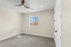 Carpeted empty room featuring a ceiling fan and recessed lighting