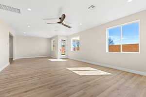 Spare room featuring light wood-type flooring, ceiling fan, healthy amount of natural light, and recessed lighting