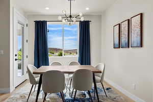 Dining area with hanging lights and light wood-type flooring