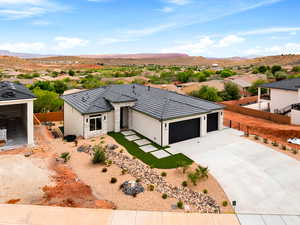 Contemporary home featuring stone siding, concrete driveway, a mountain view, a garage, and stucco siding