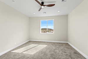 Carpeted spare room featuring ceiling fan and recessed lighting
