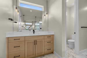 Full bathroom featuring plenty of natural light, vanity, light marble finish floors, and recessed lighting
