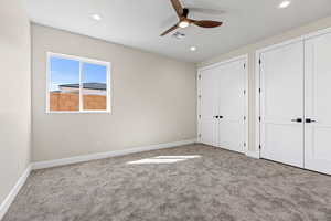 Unfurnished bedroom with multiple closets, carpet floors, ceiling fan, and recessed lighting