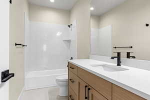 Full bathroom with vanity, shower / washtub combination, and recessed lighting