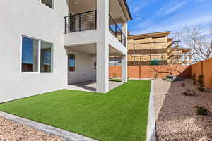 Fenced backyard featuring a balcony and a patio