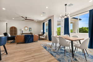 Dining room featuring suspended lighting, light wood-style flooring, and a ceiling fan