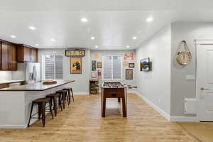 Playroom featuring light wood-style floors, recessed lighting, and beverage cooler