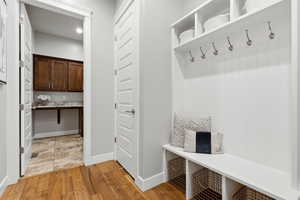 Mudroom with light wood-type flooring and baseboards