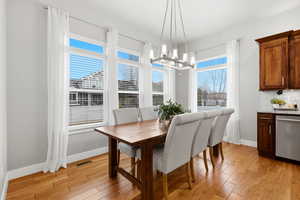 Dining area with light wood-style flooring and a chandelier