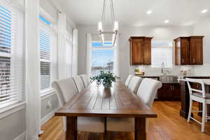 Dining area with light wood-style flooring and recessed lighting
