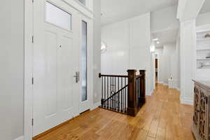 Entrance foyer with light wood finished floors and recessed lighting