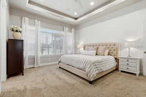 Bedroom with a tray ceiling, light carpet, a ceiling fan, and recessed lighting