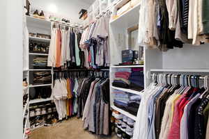 Walk in closet featuring light colored carpet