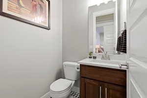 Half bathroom featuring vanity and toilet