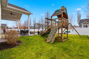 View of jungle gym featuring a fenced backyard, a ceiling fan, a patio, and outdoor dining space