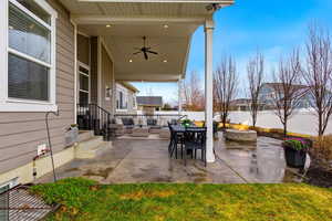 Fenced backyard with a patio, an outdoor fire pit, a ceiling fan, and an outdoor living / dining area
