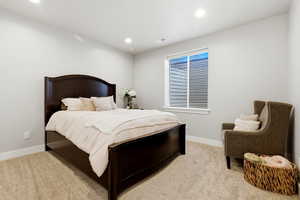 Bedroom with light colored carpet and recessed lighting