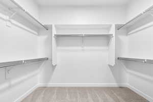 Walk in closet featuring light carpet