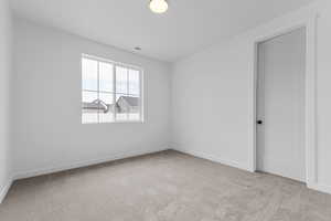 Unfurnished room featuring light colored carpet and baseboards