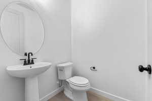 Half bath featuring toilet and light wood-type flooring