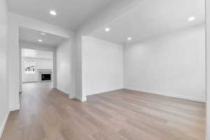 Spare room with a fireplace, recessed lighting, and light wood-type flooring