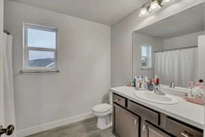 Bathroom featuring a shower with curtain, vanity, and light wood-style flooring