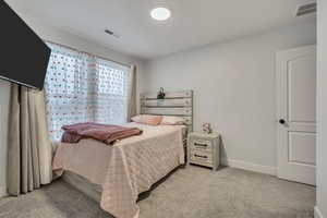 Bedroom with baseboards and light colored carpet