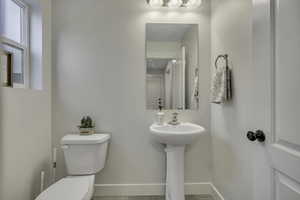 Half bathroom featuring toilet and baseboards