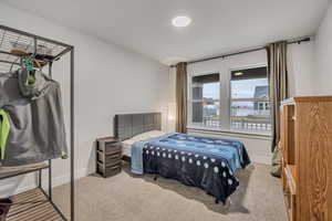 Bedroom featuring light colored carpet and baseboards