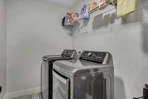 Laundry room with baseboards and washer and clothes dryer
