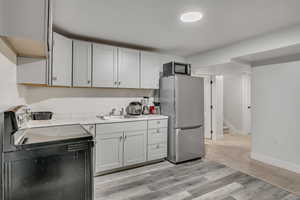 Kitchen with stainless steel appliances, washer / dryer, light countertops, and light wood finished floors