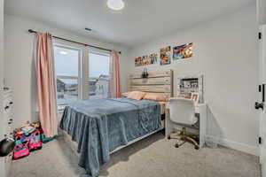 Bedroom featuring light carpet and an office area
