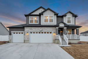 Craftsman inspired home featuring stone siding, concrete driveway, board and batten siding, covered porch, and an attached garage