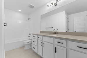 Full bath featuring vanity, shower / tub combination, and light tile patterned flooring