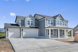 Craftsman-style house with driveway, a shingled roof, an attached garage, a porch, and board and batten siding