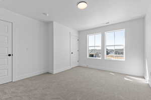 Empty room featuring baseboards and light carpet