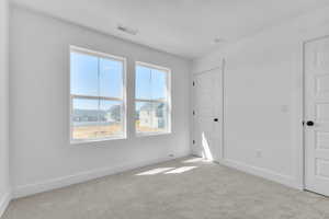 Unfurnished bedroom featuring baseboards and light colored carpet