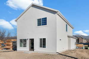 Back of property with a mountain view and stucco siding