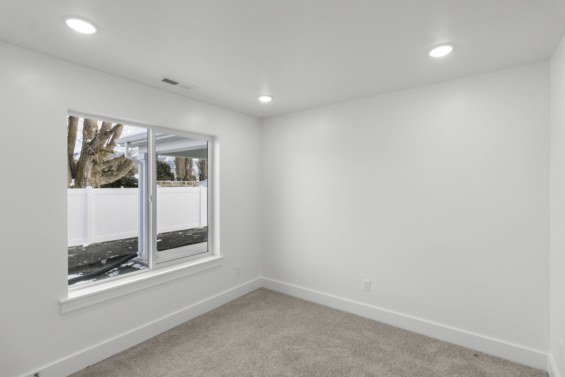 Empty room featuring light carpet and recessed lighting