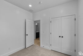 Unfurnished bedroom with light carpet, recessed lighting, and a closet