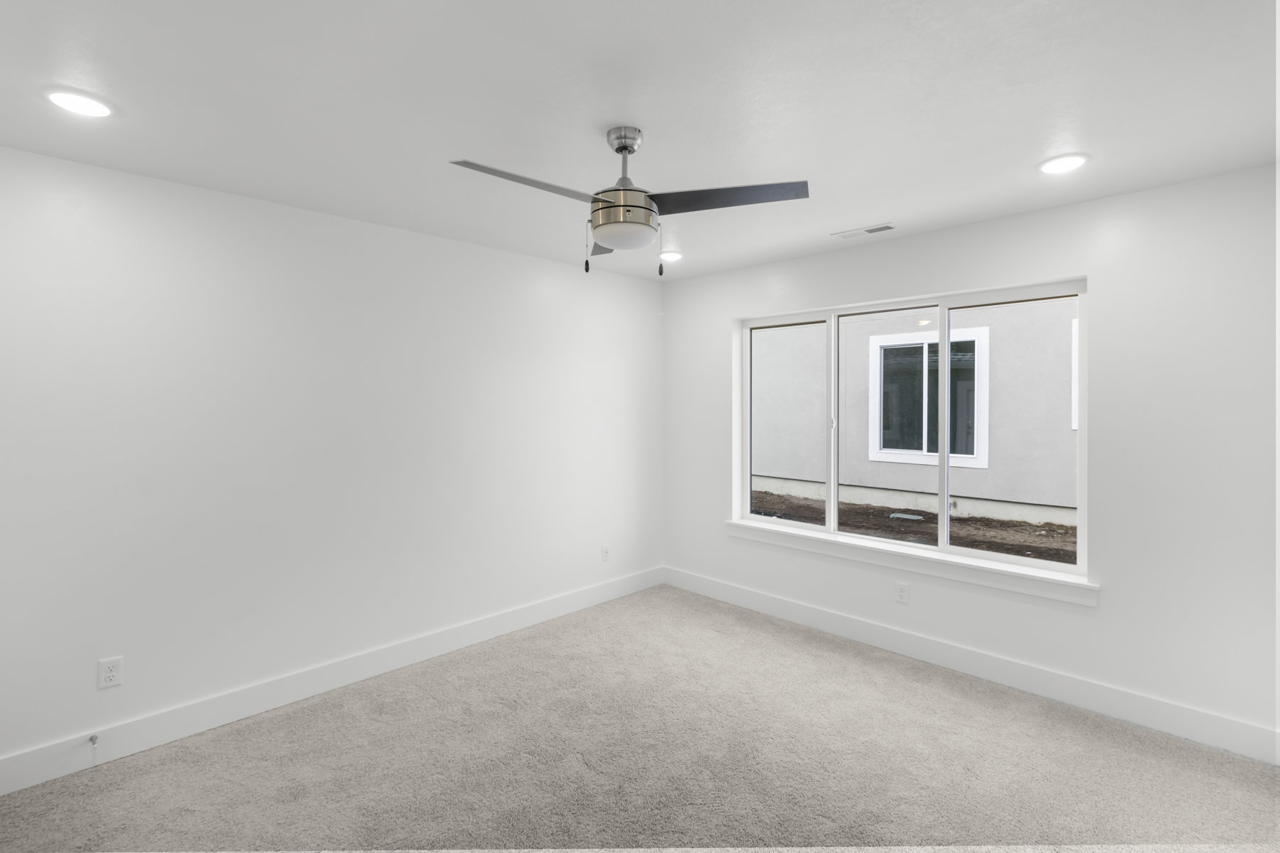 Carpeted spare room featuring a ceiling fan and recessed lighting