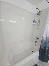 Primary Full bath with shower / bath combo with shower curtain and tile patterned flooring