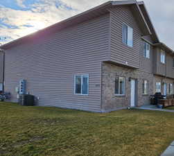 View of property exterior featuring a patio area, brick siding, and a lawn