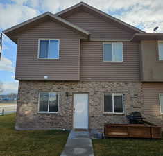Front view of property featuring brick siding and a lawn