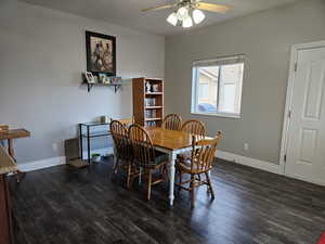Dining area with dark wood finished floors, ceiling fan, and a textured ceiling